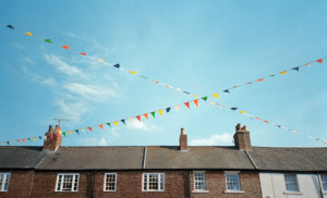 Image of houses and bunting in an English town. See our pick of the best books set in England by both English crime writers and those from further afield here.