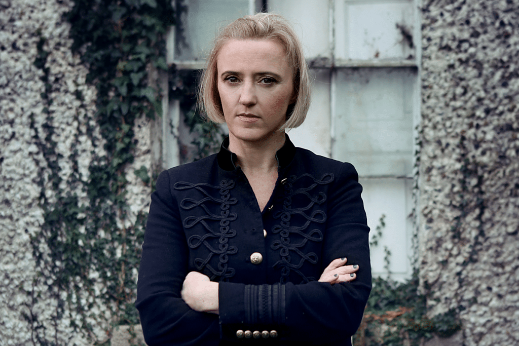 Photo of author Liz Nugent standing in front of an old building with her arms crossed. See all Liz Nugent books in order of publication below.
